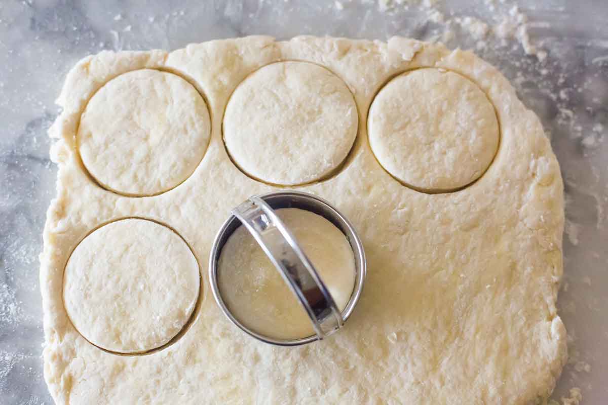 Biscuits being cut out of a rectangle of dough.