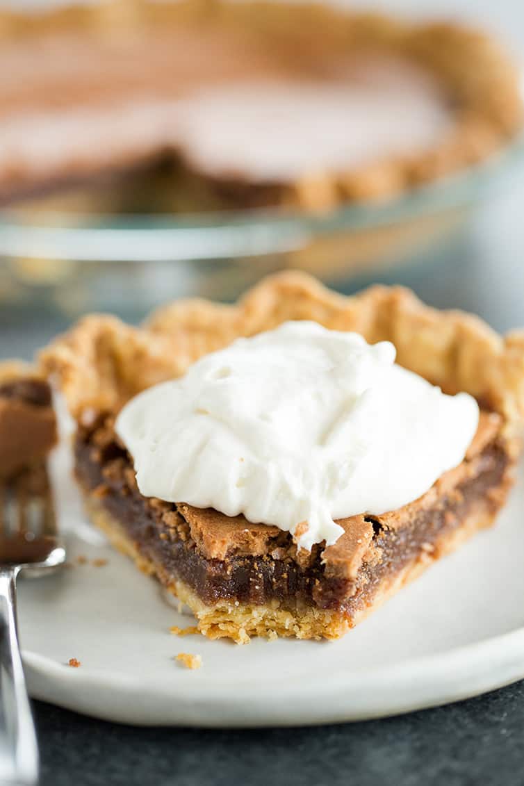 A slice of chocolate chess pie with a bite taken out of it.