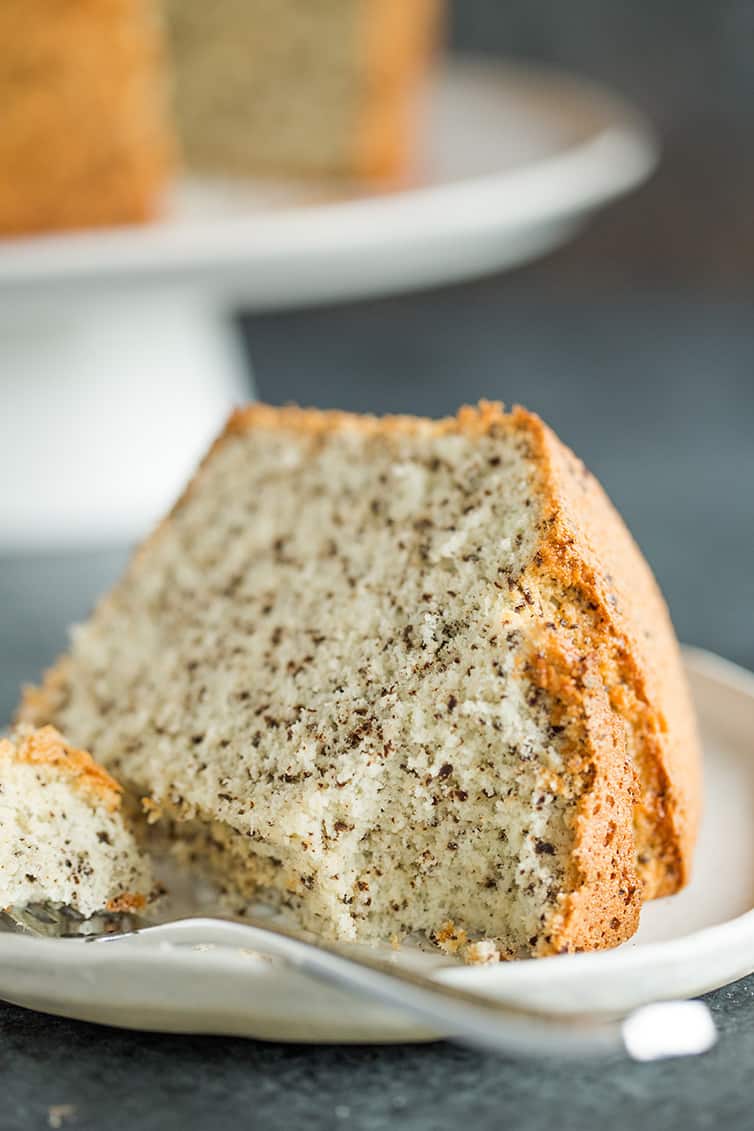 A slice of chocolate chip chiffon cake on a plate with a forkful taken out.