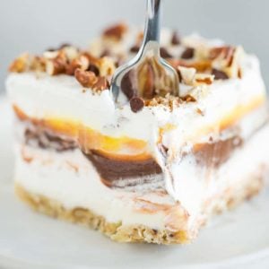 A fork going through a piece of chocolate lush dessert.
