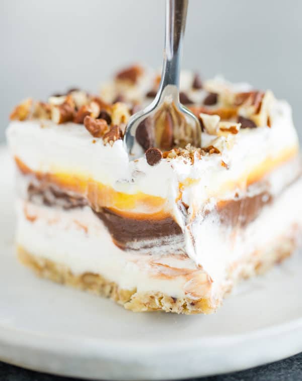 A fork going through a piece of chocolate lush dessert.