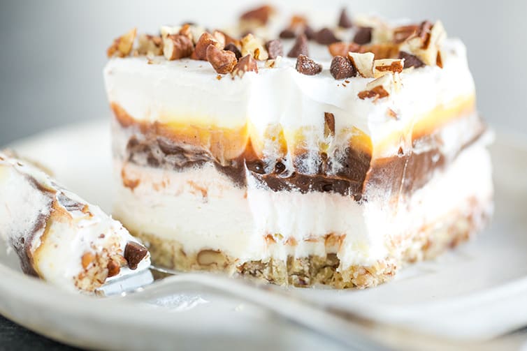 A piece of chocolate lush dessert with a forkful taken out of it.