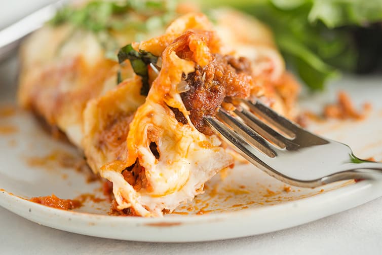 A forkful of cheesy chicken parmesan.