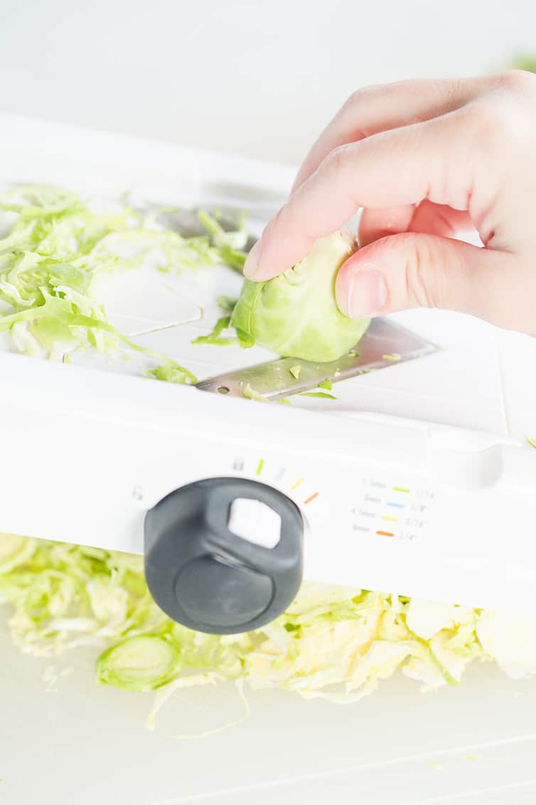 Slicing Brussels sprouts on a mandoline.