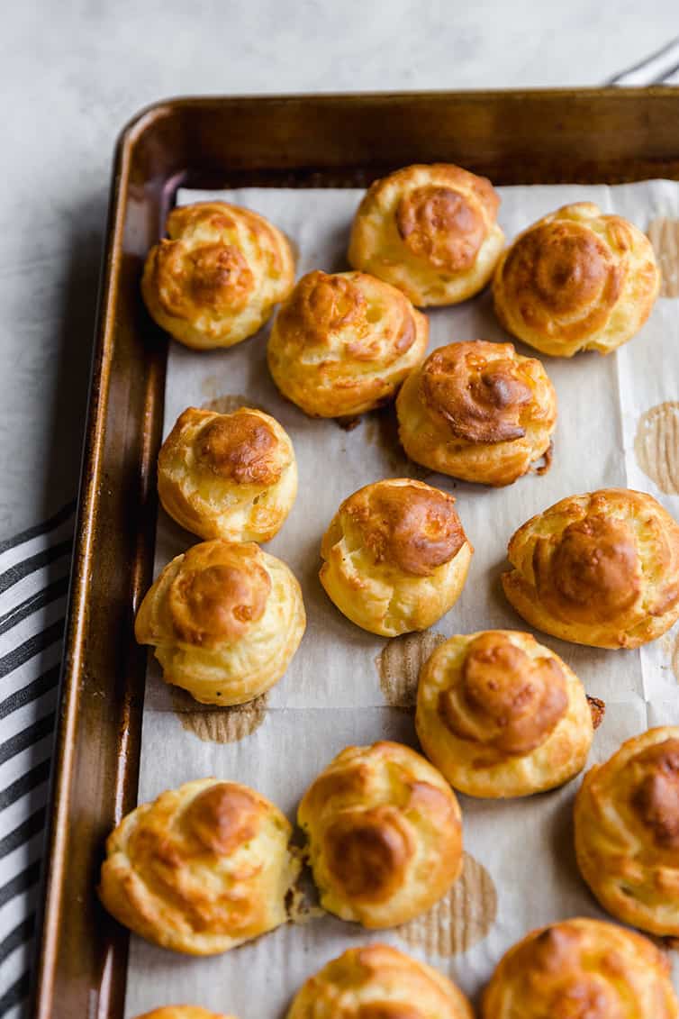 Baked gougeres on a baking sheet.