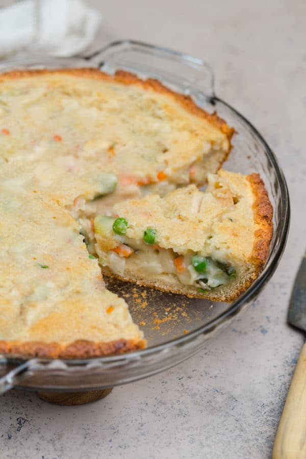 Chicken pot pie on a counter with a slice cut and ready to serve