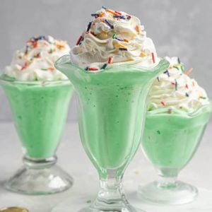 Three milkshake glasses filled with copycat McDonald's shamrock shakes.