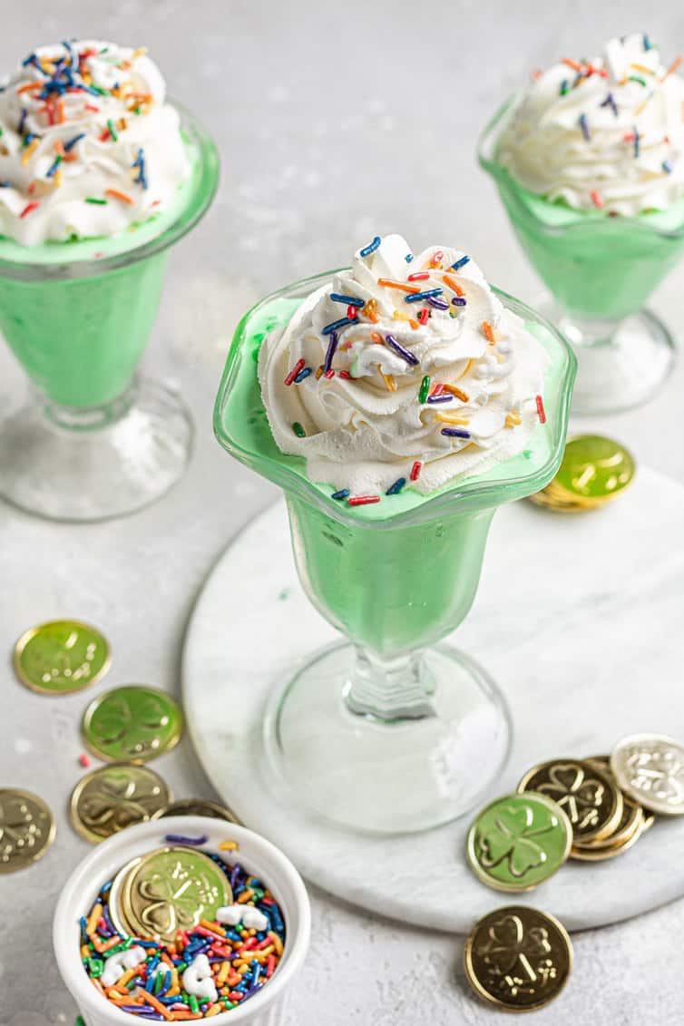 Three McDonald's shamrock shakes with gold coins.