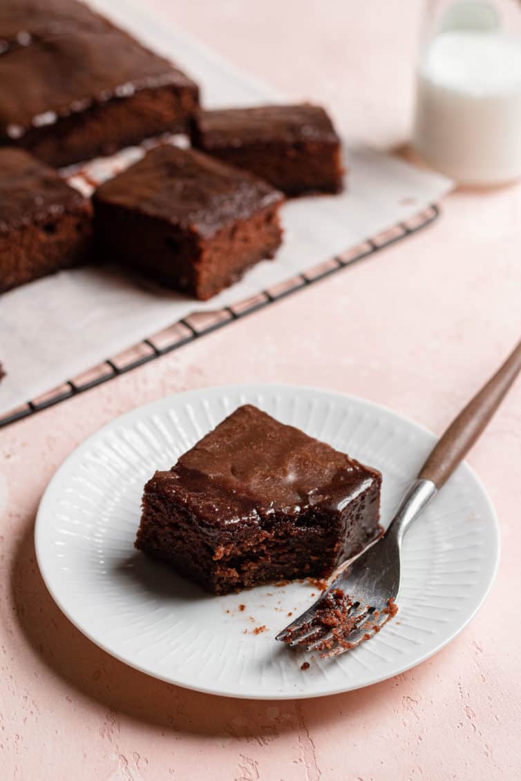 A slice of coca cola cake on a plate with a fork.