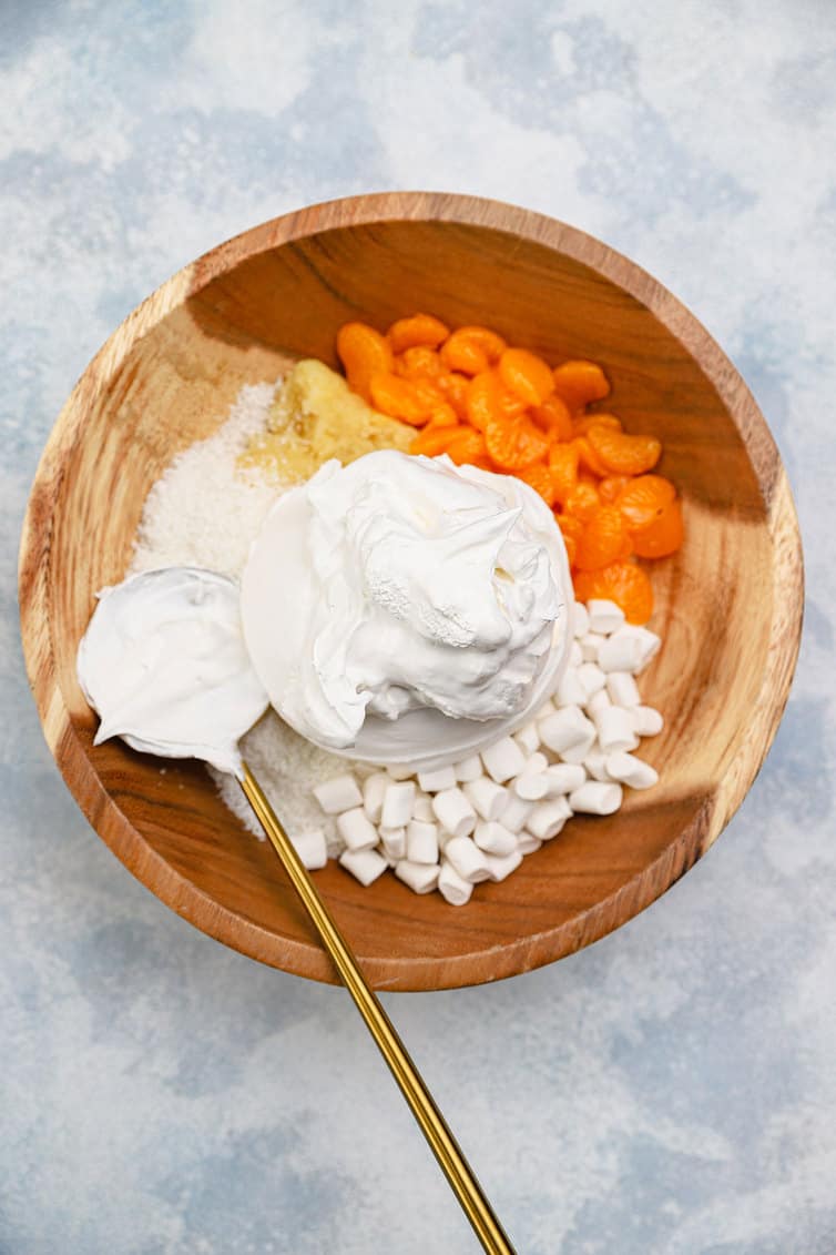 Ingredients for ambrosia in a wooden bowl.