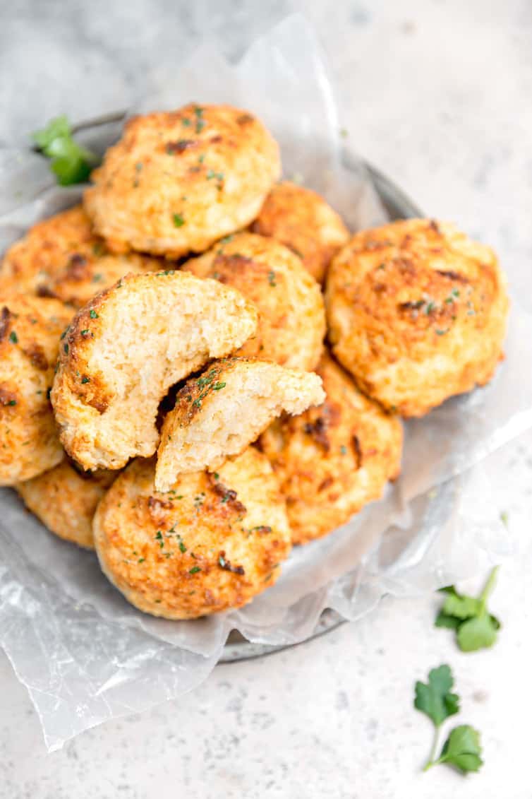 Bowl of cheddar bay biscuits with one broken in half.
