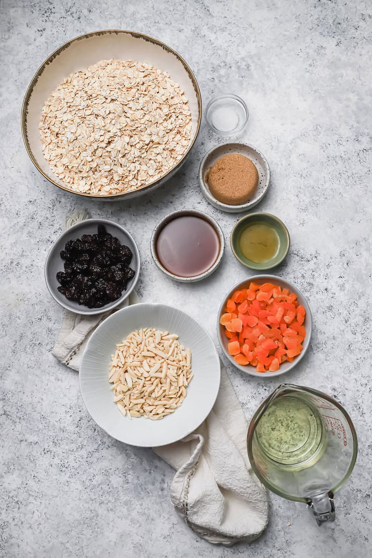Ingredients for granola prepped in bowls on a counter.