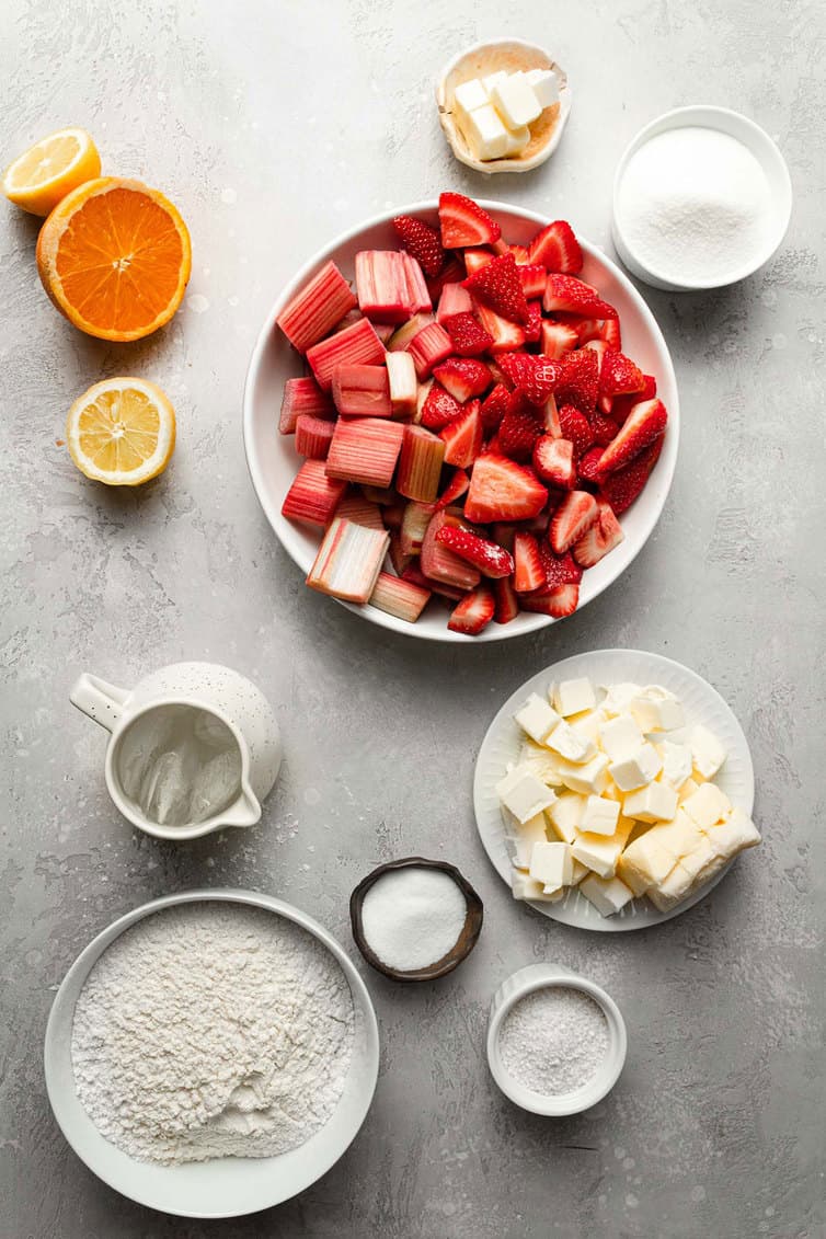 Ingredients for strawberry rhubarb pie prepped in bowls on counter.
