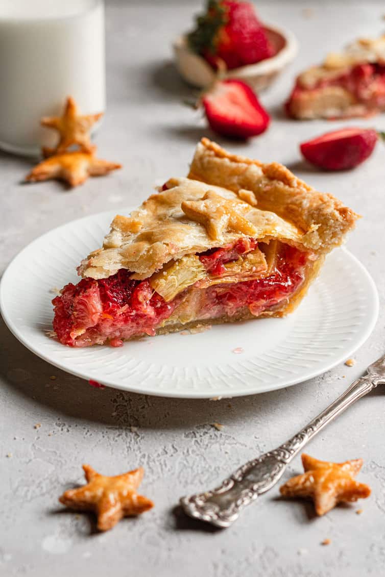 A slice of strawberry rhubarb pie on a white plate.