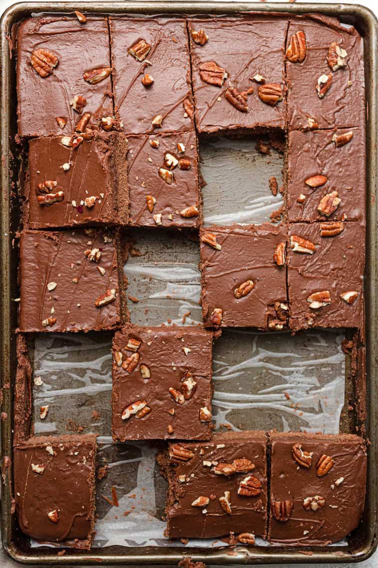 A pan of Text sheet cake with several pieces missing.