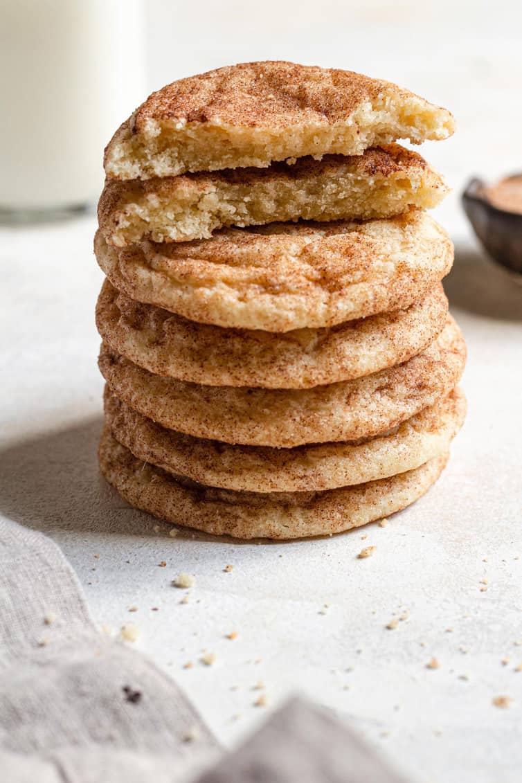 A stack of snickerdoodles with one broken in half on top.