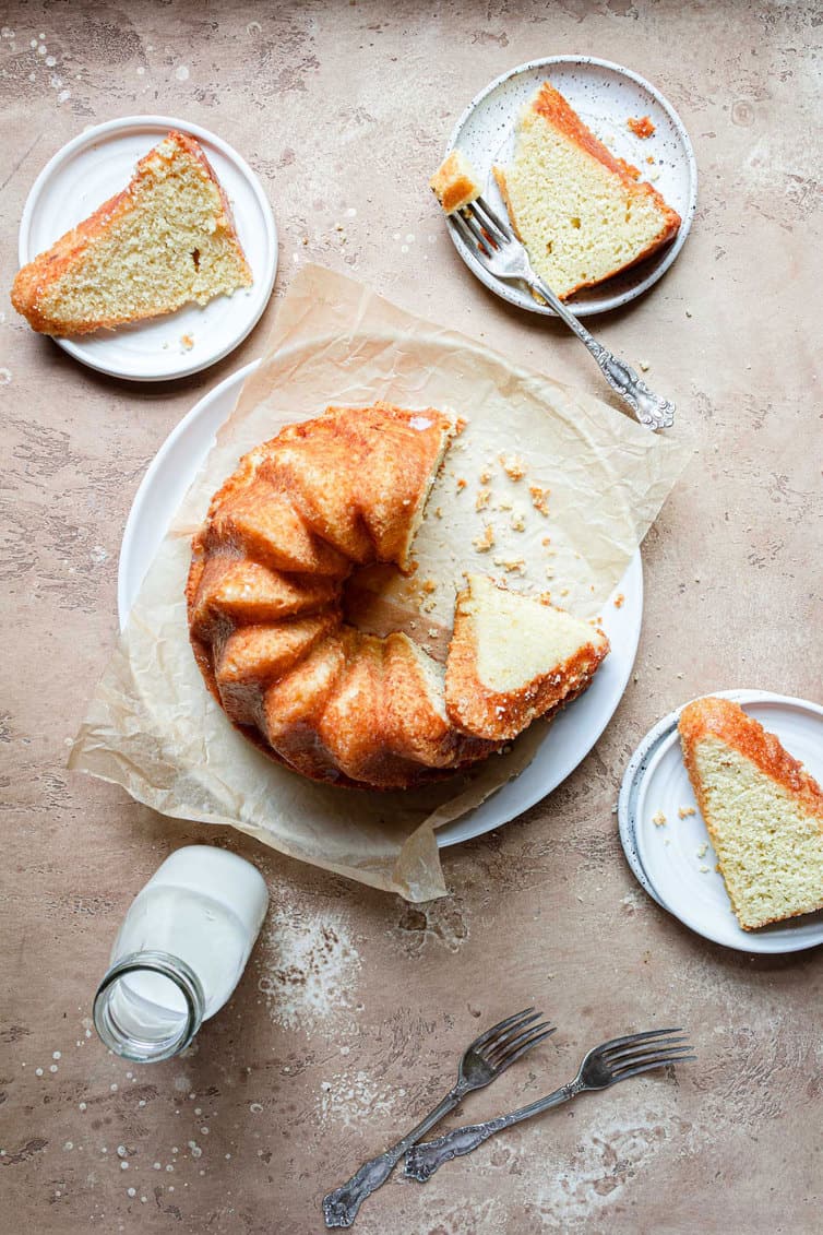 Overhead photo of butter cake with three slices on plates around it.