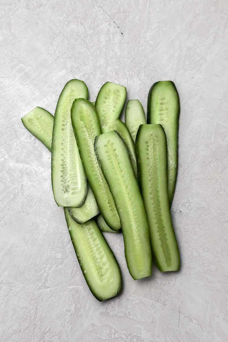 Pickling cucumbers sliced lengthwise.
