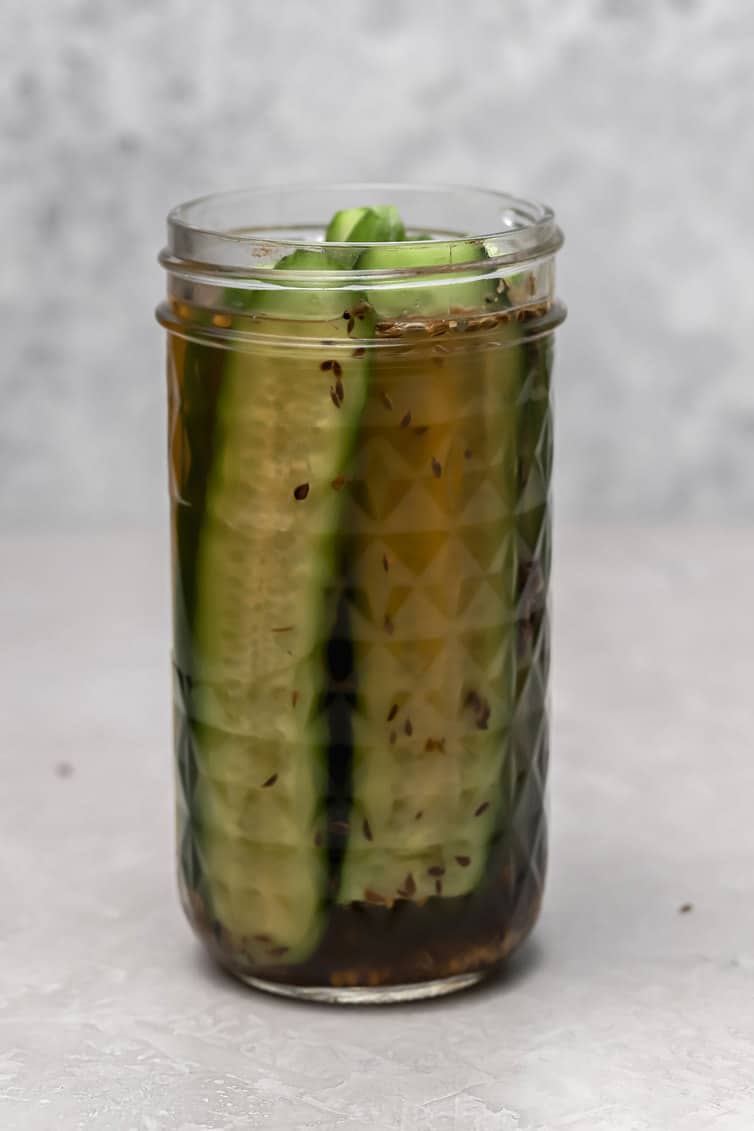 A jar of dill pickles without the lid on.