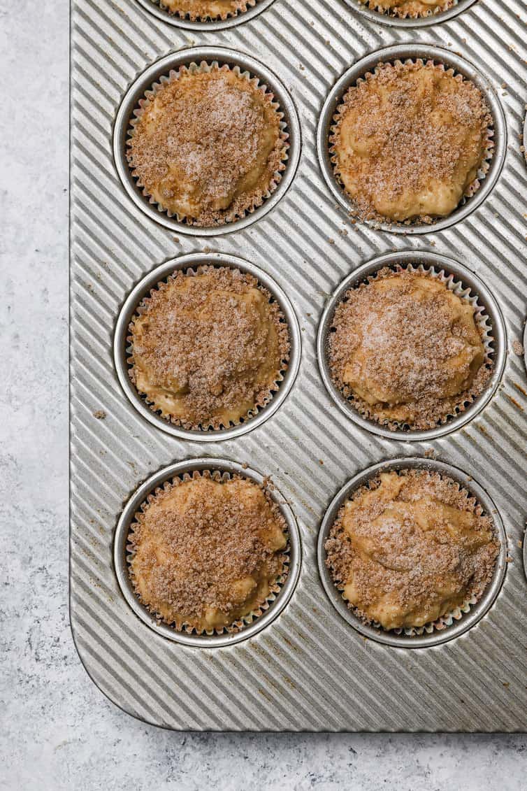 Apple muffin batter topped with cinnamon-sugar before baking.