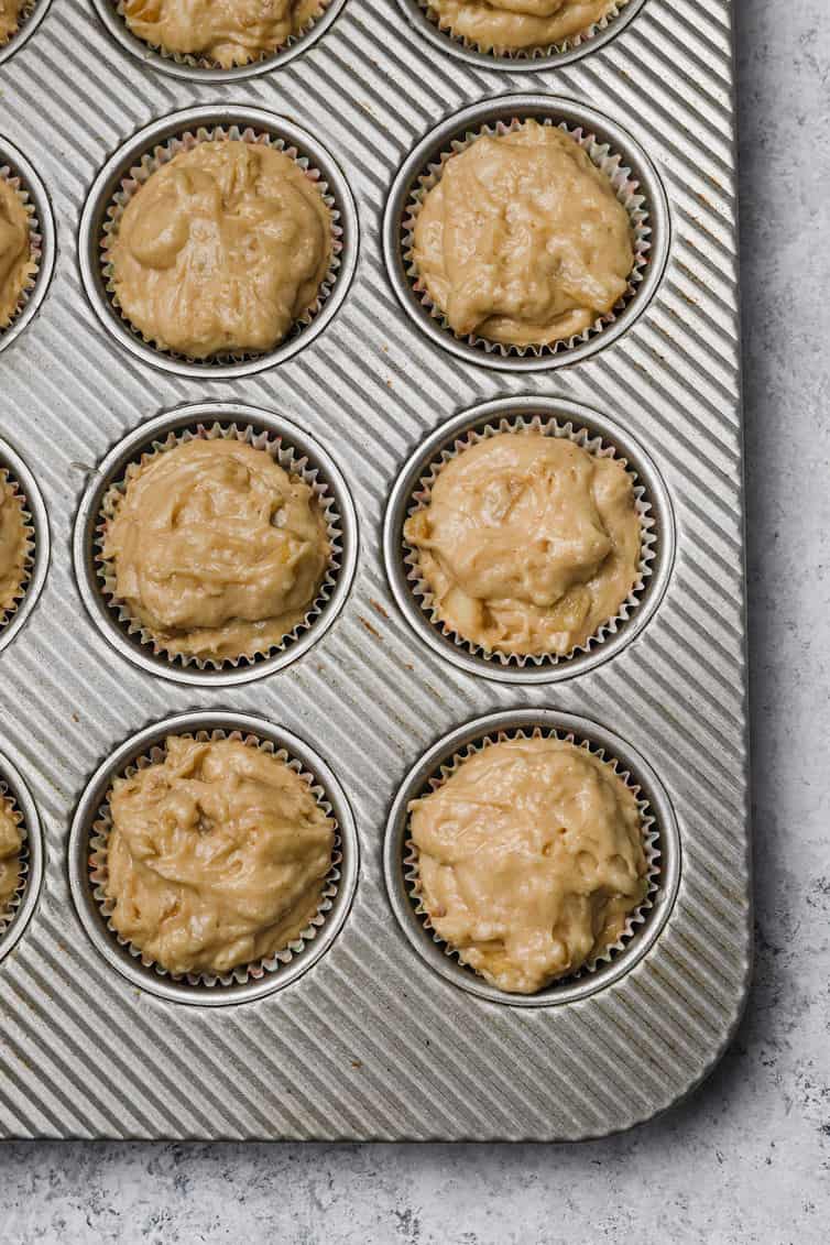 Apple muffin batter in muffin pan.
