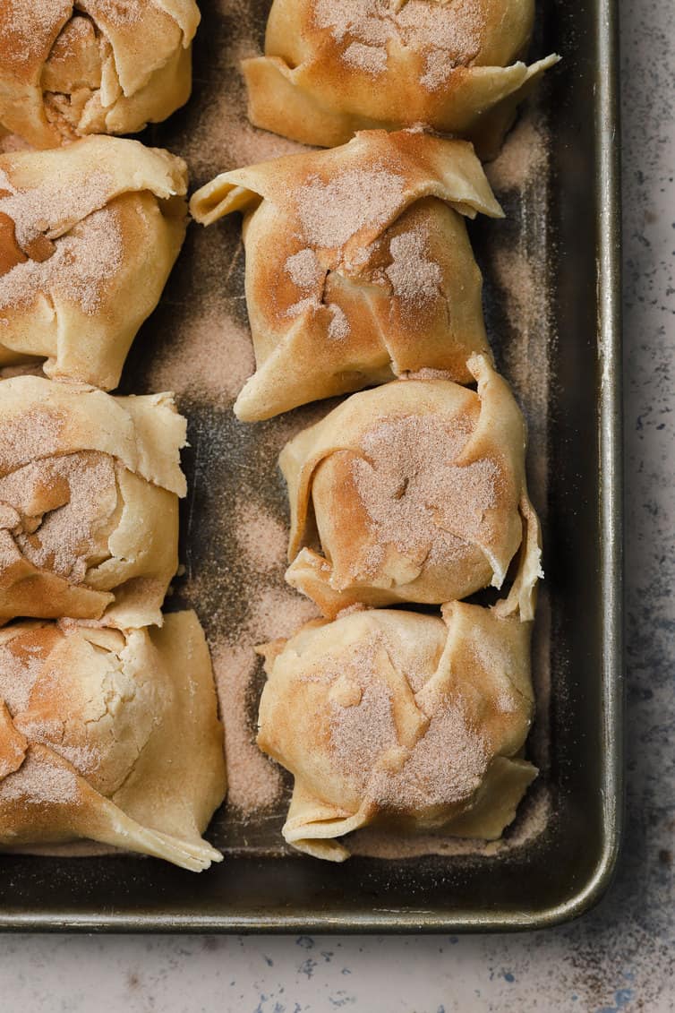 Prepared apple dumplings in a baking pan.