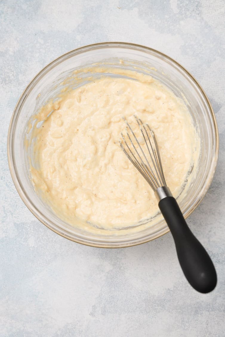 Hush puppy batter in a bowl with a whisk.