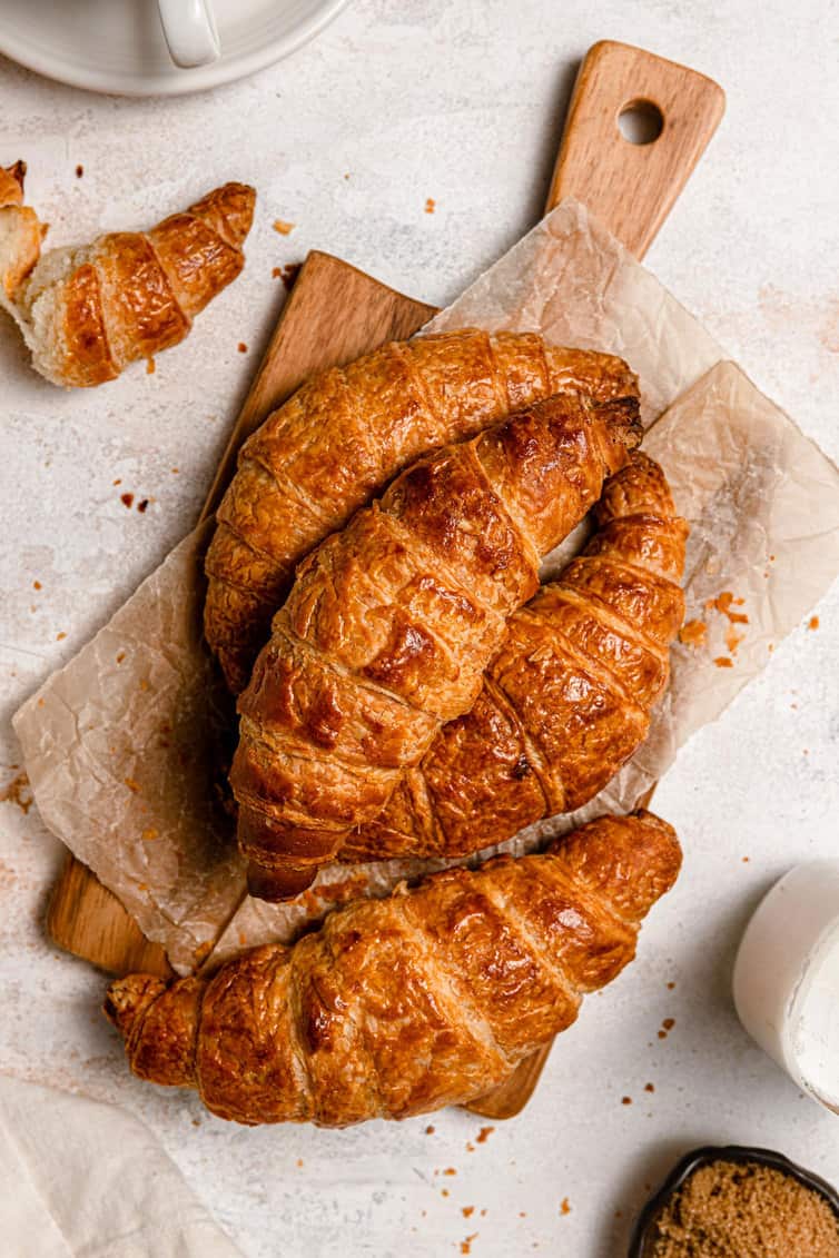 A pile of homemade croissants on a cutting board.