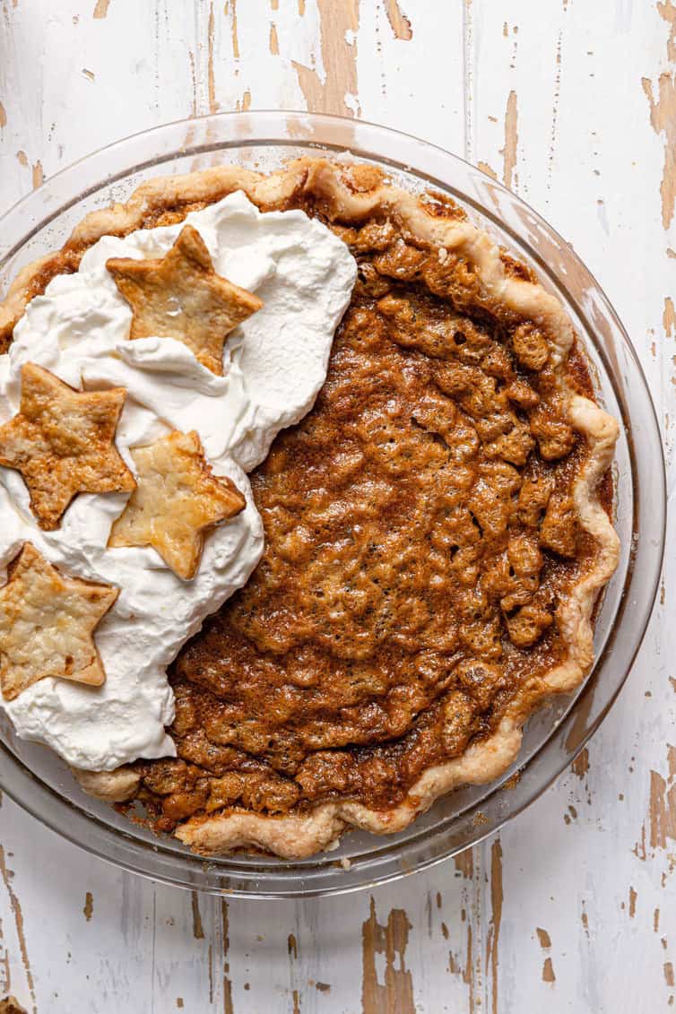 Chocolate walnut bourbon pie with whipped cream on half.