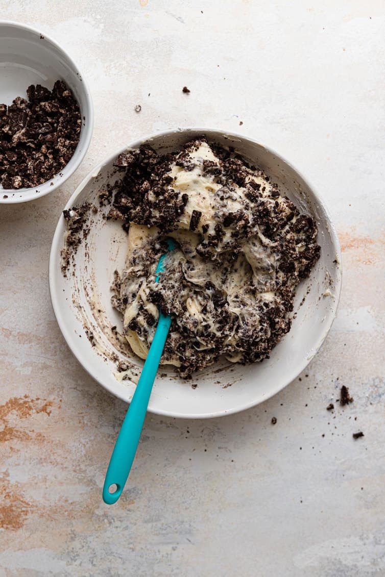Crushed Oreos stirred into cream cheese frosting.