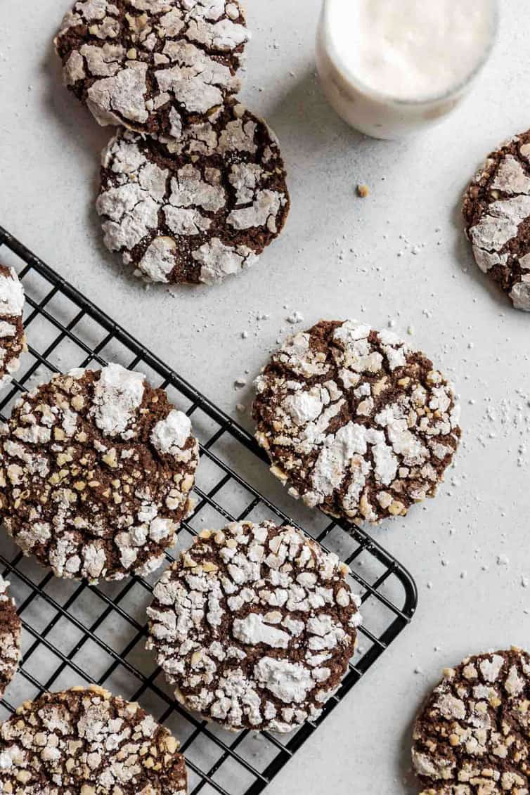 Nutella cookies on a cooling rack with a glass of milk nearby.