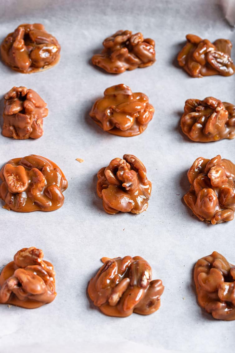 Pecan pralines sitting on parchment paper.