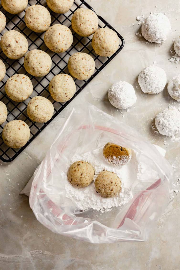 Rolling snowball cookies in powdered sugar.