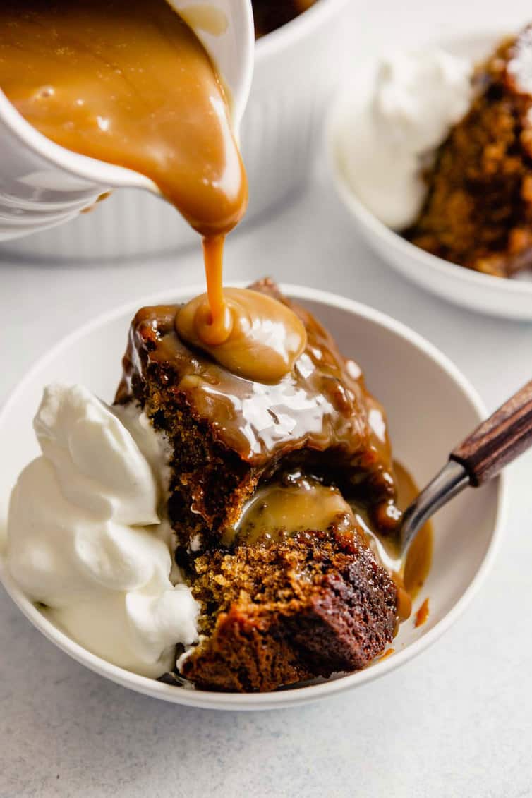 Pouring toffee sauce on sticky toffee pudding.