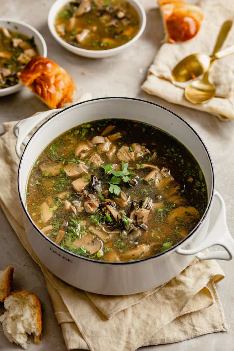 Big pot of turkey wild rice soup with smaller bowls in the background.