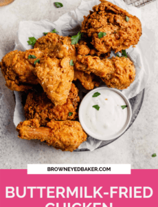 A silver plate with buttermilk fried chicken and a small bowl of ranch with a pink rectangle at the bottom and the words Buttermilk-Fried Chicken in white.