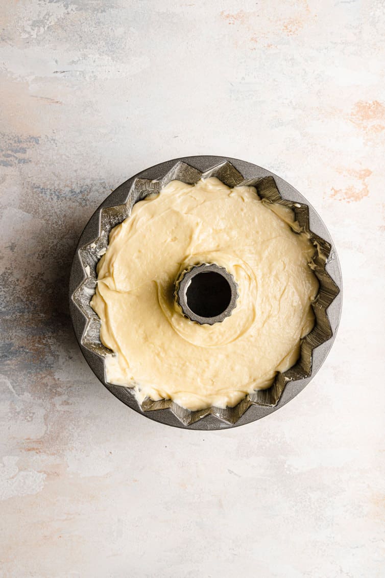 Cream cheese pound cake batter spread in a Bundt pan.