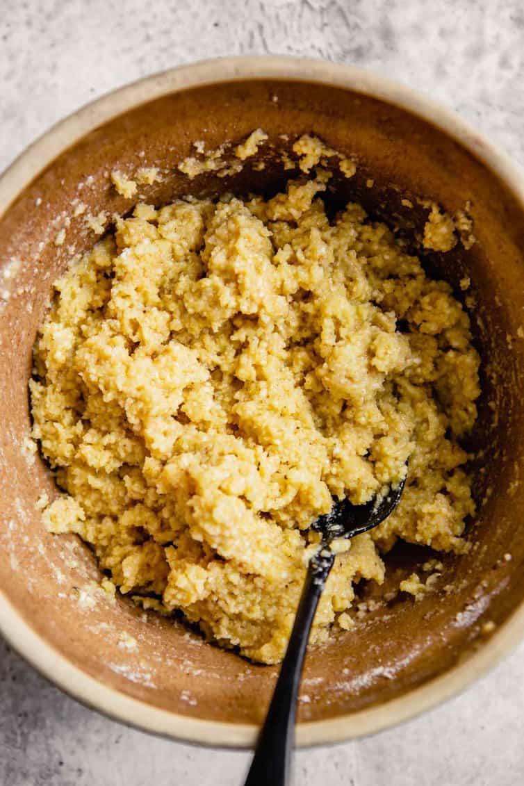 A bowl of matzo ball dough with a silver spoon.