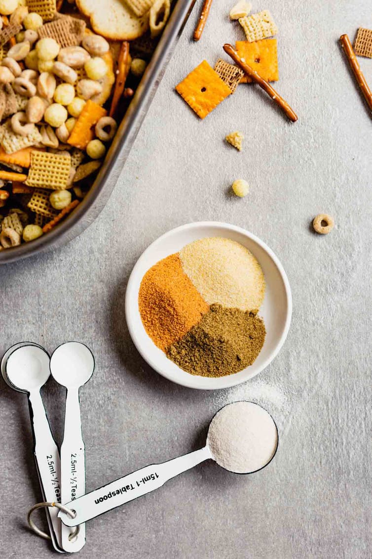 Seasonings measured into a bowl for nuts and bolts recipe.
