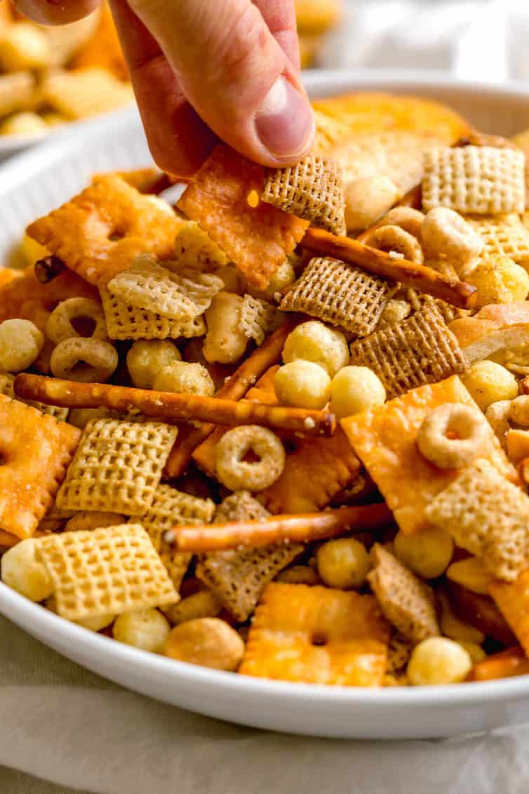 Fingers picking up nuts and bolts out of a bowl.