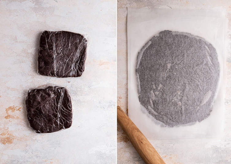 Oreo cookie dough being rolled out between parchment paper.
