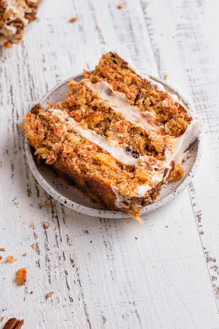 Slice of carrot cake on its side on a plate.