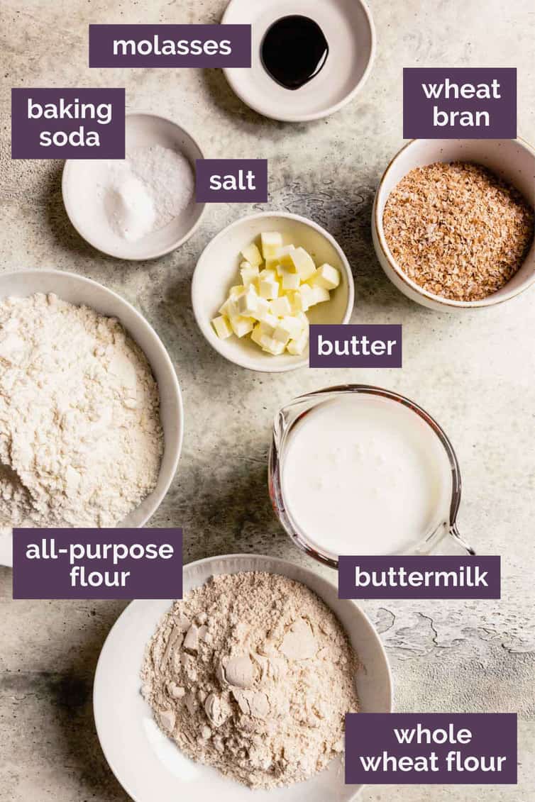 The ingredients for Irish brown bread in bowls on a counter labeled with that each ingredient is.