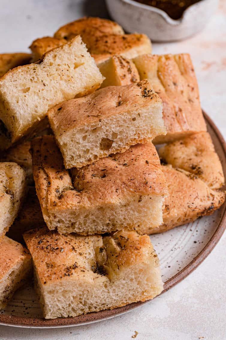 A small plate with sliced pieces of garlic herb focaccia.