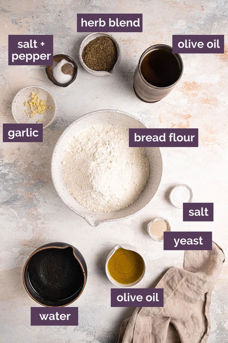 Labeled ingredients for focaccia on a white counter.