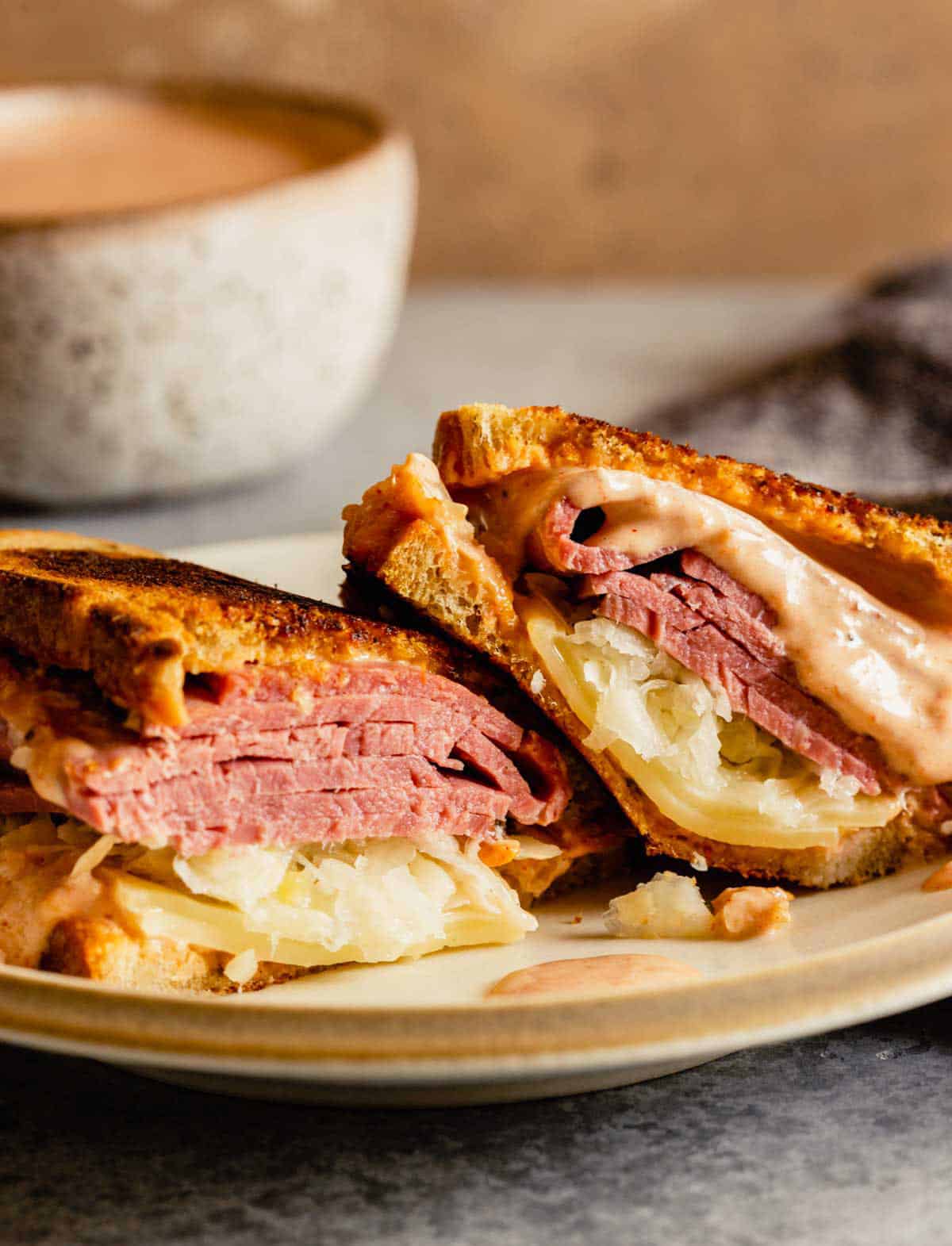 A Reuben sandwich cut in half on a plate.