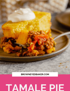 A piece of tamale pie on a brown plate with a fork topped with tamale pie with a pink rectangle at the bottom that says Tamale Pie.