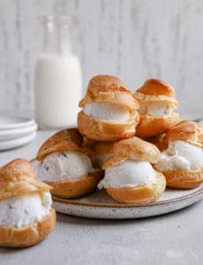 Pate a choux puffs split in half with ice cream in the middle.