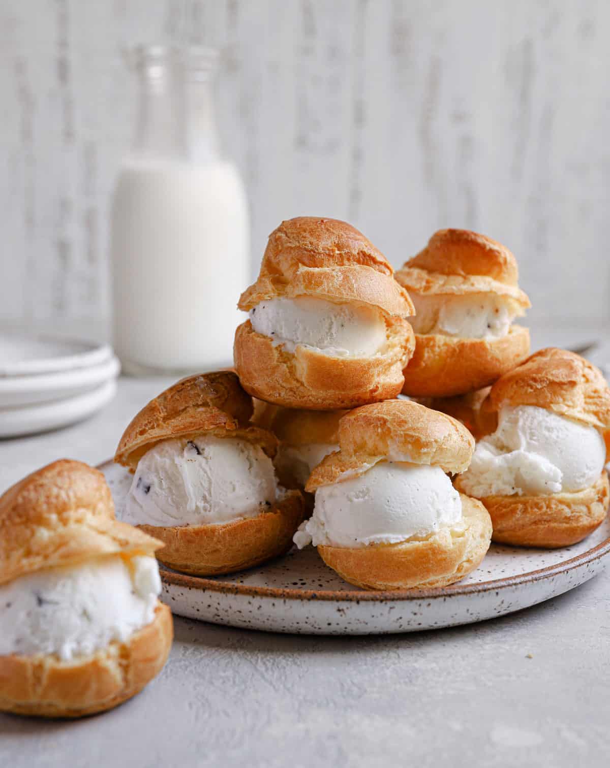 Pate a choux puffs split in half with ice cream in the middle.
