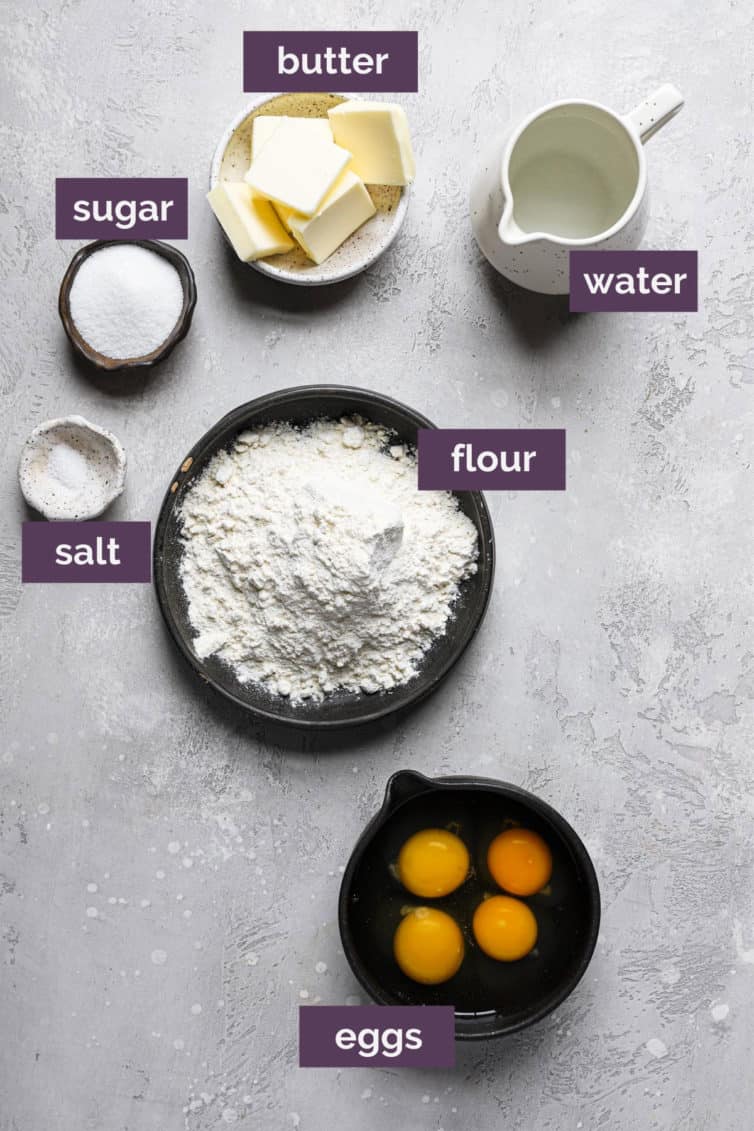 Ingredients for profiteroles on a white grey counter labeled with purple rectangles.